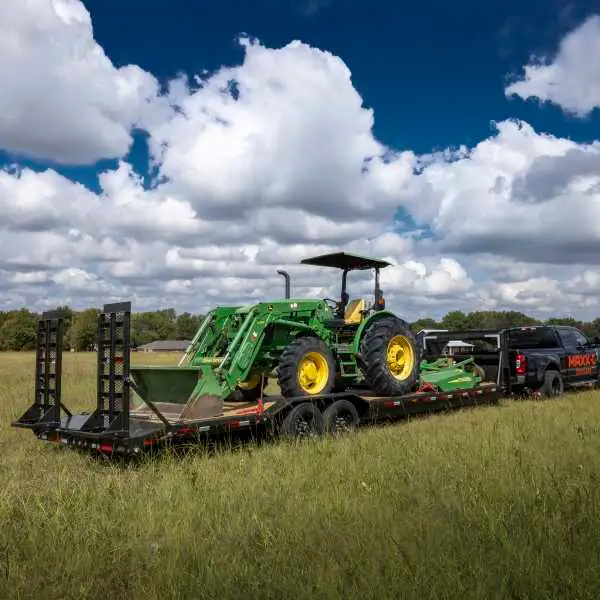 Equipment hauler moving tractor