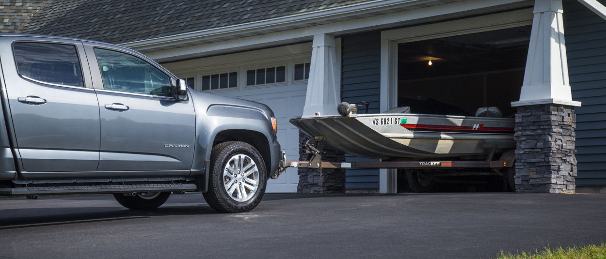 Truck with CURT front hitch parking a boat trailer